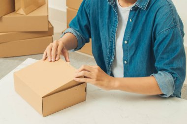 Delikanlı teslimat için paket paketliyor.