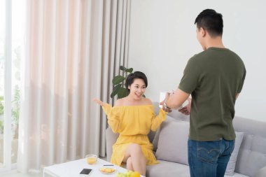 kız arkadaşıyla evde oturma odasında kanepede hediye şaşırtıcı adam