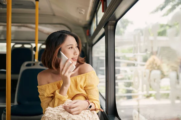 アジアの女の子は公共のバスで携帯電話を使用して — ストック写真