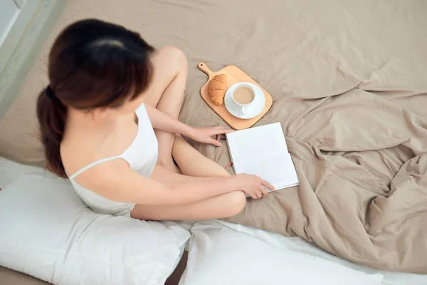 Junge Frau Sitzt Bett Beim Lesen Eines Buches Mit Kaffeetasse — Stockfoto