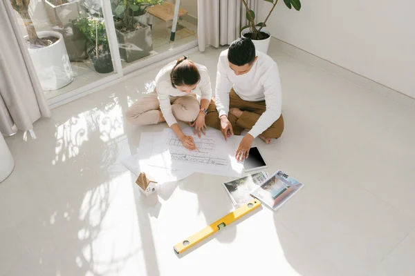 若い夫婦は新しい家の設計図を見ている インテリアデザインの企画 — ストック写真