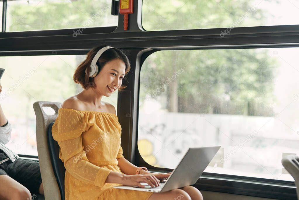 Young businesswoman on a business travel. Working on the bus using her laptop.