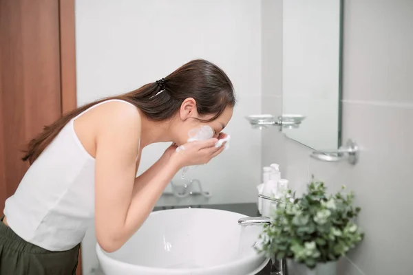Asian woman cleaning face skin enjoy herself with bubble cleansing foam.