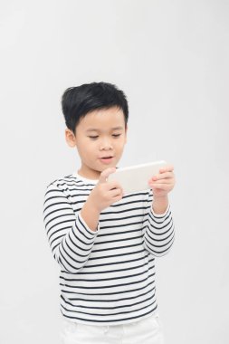 Asyalı mutlu çocuk akıllı telefonda oynuyor.