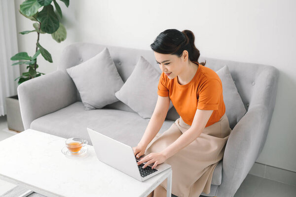 Happy girl browsing through the internet during free time at home.