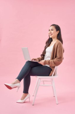 Kız internette sörf yapıyor ve ilginç bilgiler arıyor. Dizüstü bilgisayarıyla çalışıyor..