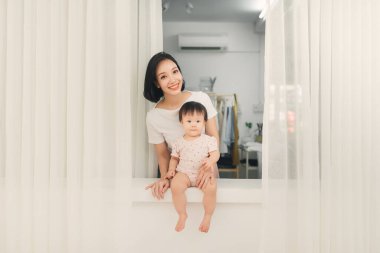 Pencerenin yanındaki eşikte oturan anne ve kızı