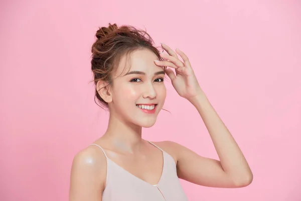 Beautiful happy woman face cosmetic concept healthy clean skin natural isolated over pink background.
