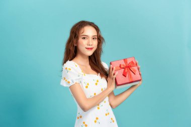 Mavi üzerinde hediye kutusu olan mutlu bir kız.