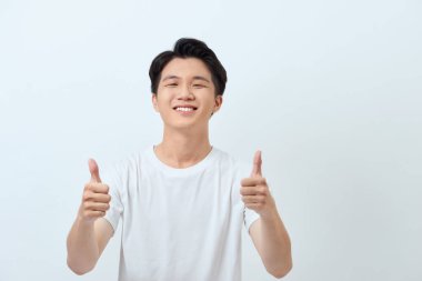 Çekici, yakışıklı Asyalı bir adamın gülümseyen ve işaret gösteren bir fotoğrafı.