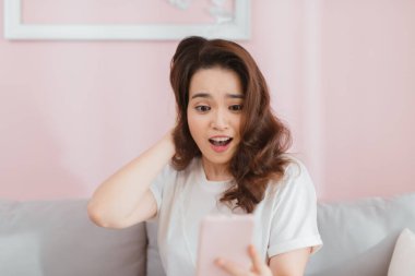 Asyalı kadın evde oturma odasında şok edici metin okuma