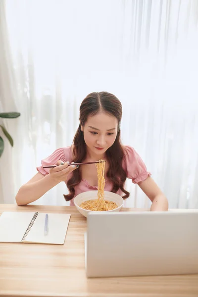 Νεαρή Ασιάτισσα Που Χρησιμοποιεί Φορητό Υπολογιστή Ενώ Τρώει Νουντλς Στο — Φωτογραφία Αρχείου