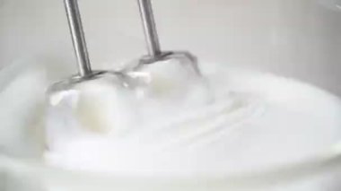 Cam kasede beyaz krema ve ahşap masada mikser. Sünger keki veya kırmızı kadife kek yapmak.