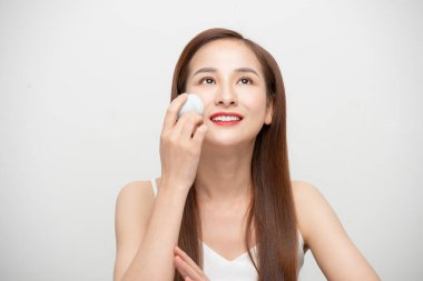 Beyaz arka planda sünger blenderi olan güzel bir genç kadının portresi..