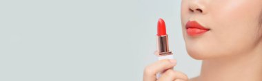 Güzel bir genç kadın kırmızı ruj sürüyor arka planda, yakın plan