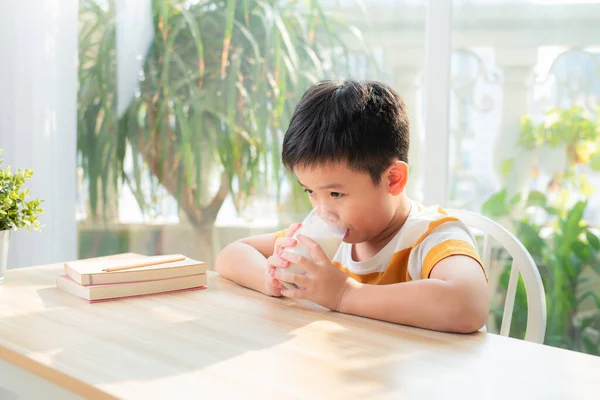 Χαριτωμένο Αγόρι Πίνοντας Ένα Ποτήρι Γάλα Κάθεται Ένα Τραπέζι Αφού — Φωτογραφία Αρχείου