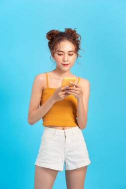 Elinde cep telefonu tutan, yaz kıyafetleri içinde heyecanlı bir genç kızın portresi.