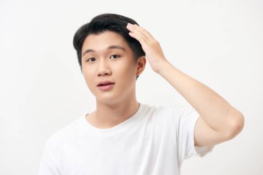 Bir elini başının arkasında tutan, gülümseyen, beyaz bir arka planda genç bir adamın portresi.