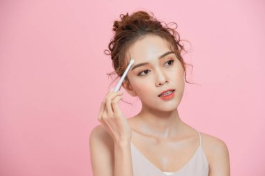 Makyaj yapan çekici bir kız, asilzade suratı uyguluyor. Makyaj, moda, kozmetik.