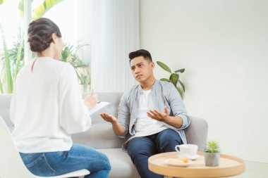 Psikolog danışmanlığı ve psikolojik terapi seansı. Stresli bir adam, depresyonunu ve sorunlarını doktorlara anlatıyor.. 
