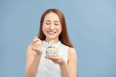 Diyet Beslenme Konsepti. Yoğurt, kuru üzüm ve yulaf ezmesi yiyen güzel kız.