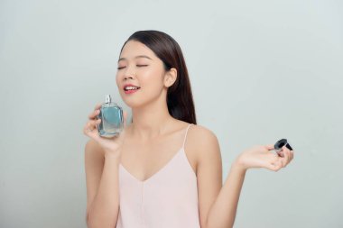 Güzel genç bir kadın parfümünü kokluyor