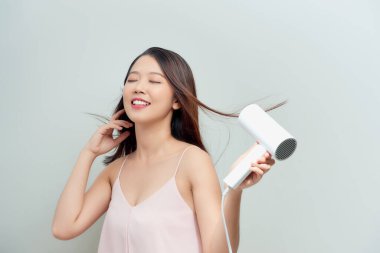 Saç kurutan güzel bir genç kadının portresi. Gülümseyen sevimli genç bayan. .