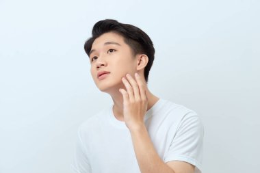 Genç yakışıklı adam cildini kontrol ediyor. 