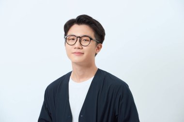 Mavi gömlekli, gülümseyen Asyalı bir adamın portresi.