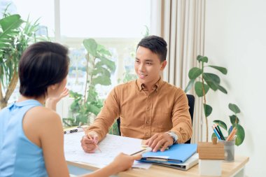 Genç mimarlar inşaat planını tartışıyor