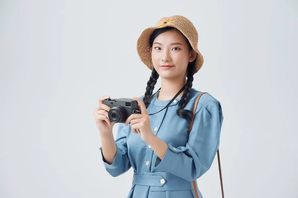 年轻快乐的女旅游摄影师很兴奋 拿着相机 戴着白色背景的帽子 — 图库照片
