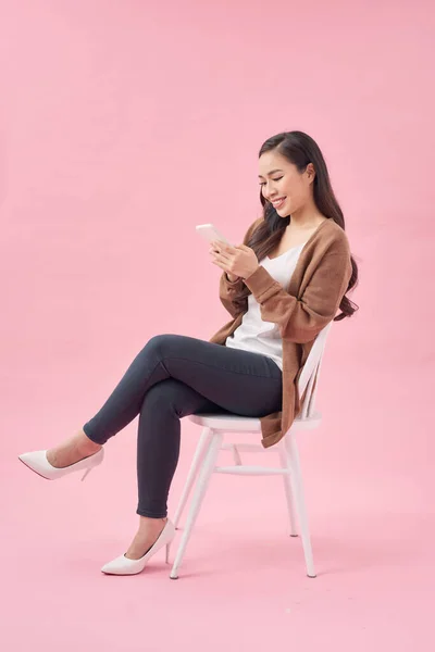 Portrét Spokojené Ležérní Asijské Ženy Pomocí Mobilního Telefonu Zatímco Sedí — Stock fotografie