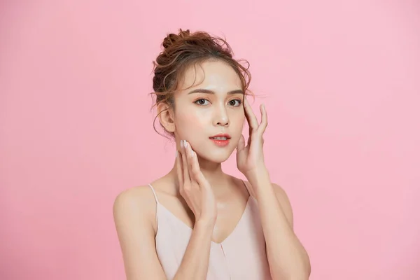 きれいな新鮮な肌のタッチ自身の顔を持つ美しい若い女性 顔の治療 — ストック写真