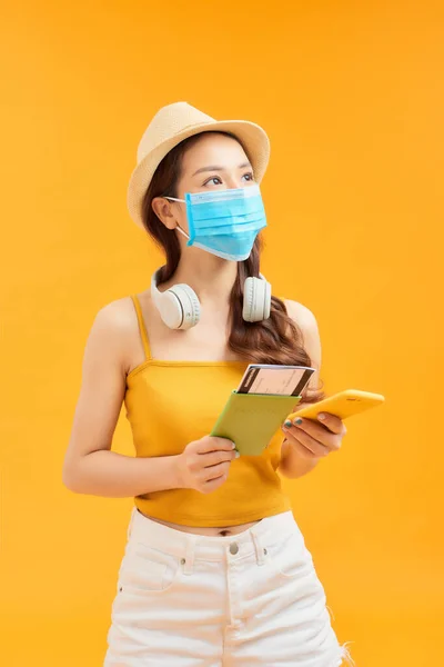 Νεαρή Ασιάτισσα Που Κρατάει Τηλέφωνο Διαβατήριο Και Φοράει Μάσκα Προσώπου — Φωτογραφία Αρχείου