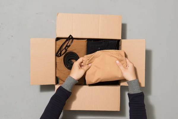 People Putting Clothes Inside Donation Box