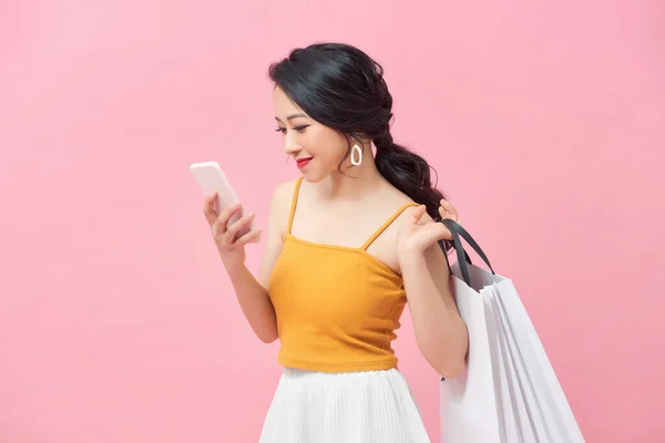 Hermosa Chica Está Sosteniendo Bolsas Compras Utilizando Teléfono Inteligente Sobre —  Fotos de Stock