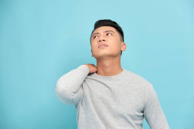 Omzu ağrıyan bir adam mavi üzerine izole edilmiş.