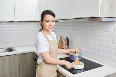 Kadın evde lezzetli yemekler pişiriyor.