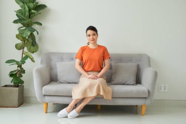 Kanepede oturan genç ve güzel bir kadın.