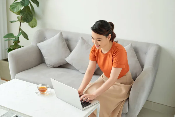 Молода Жінка Розслабляється Вдома Дивані Неї Чай Використовує Ноутбук — стокове фото