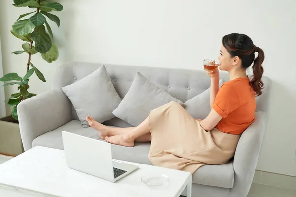 Young Woman Relaxing Home Couch She Having Tea Using Laptop — Stock Photo, Image