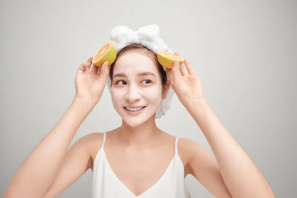 Joven Asiática Teniendo Blanco Facial Máscara Arcilla Celebración Naranja Pieza — Foto de Stock