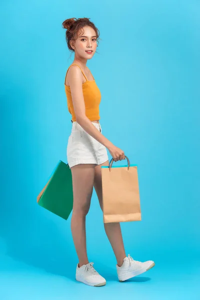 迷人而快乐的微笑时尚的女人购物狂带着购物袋蓝色工作室背景 销售兴奋 时尚潮流 — 图库照片