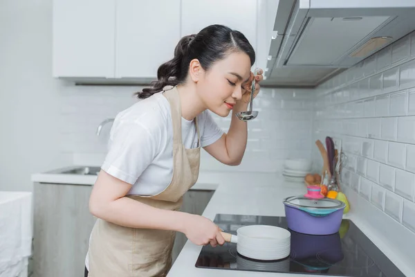 Jonge Vrouw Proeven Eten Met Lepel Keuken — Stockfoto