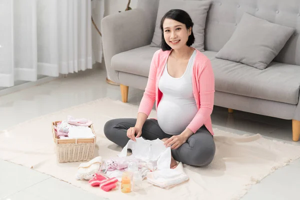 Mujer Embarazada Con Ropa Bebé Casa — Foto de Stock