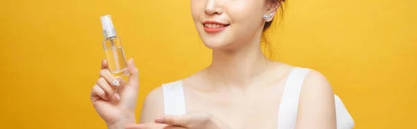 Krásná Asijská Žena Stojící Drží Sprej Láhev Žluté Pozadí — Stock fotografie