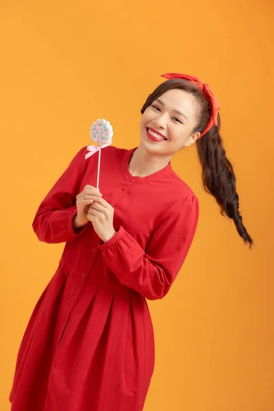 Lachende Jonge Vrouw Houden Lolly Oranje Achtergrond Kijken Naar Camera — Stockfoto