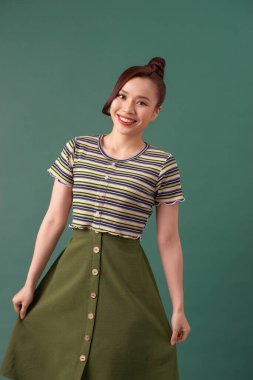 Temiz ciltli, doğal makyajlı ve yeşil arka planda beyaz dişli güzel bir kadın.