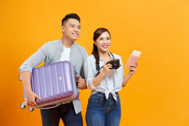 Gülümseyen genç turistler birkaç arkadaş. Sarı arka planda izole edilmiş yaz elbiseli bir kız.. 