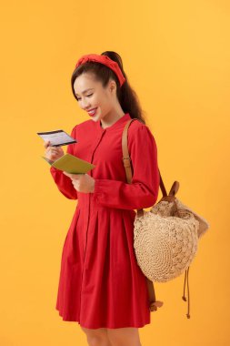 Genç Asyalı kadın uçağa binmeden önce uçuş biletini düzeltiyor.